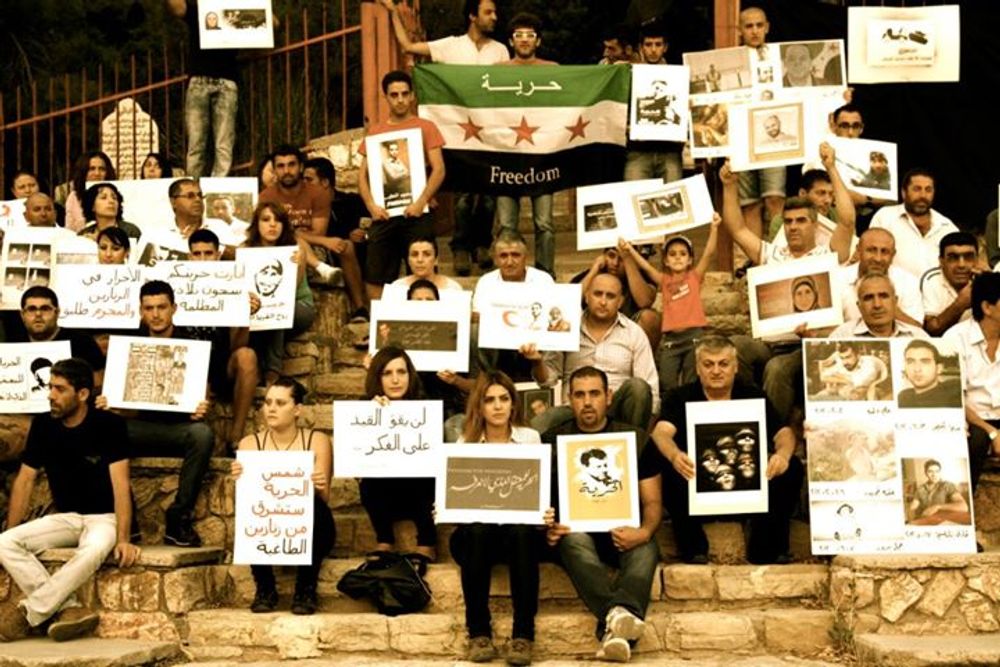 Syrian protestors holding up signs for Mohammed while he was in prison