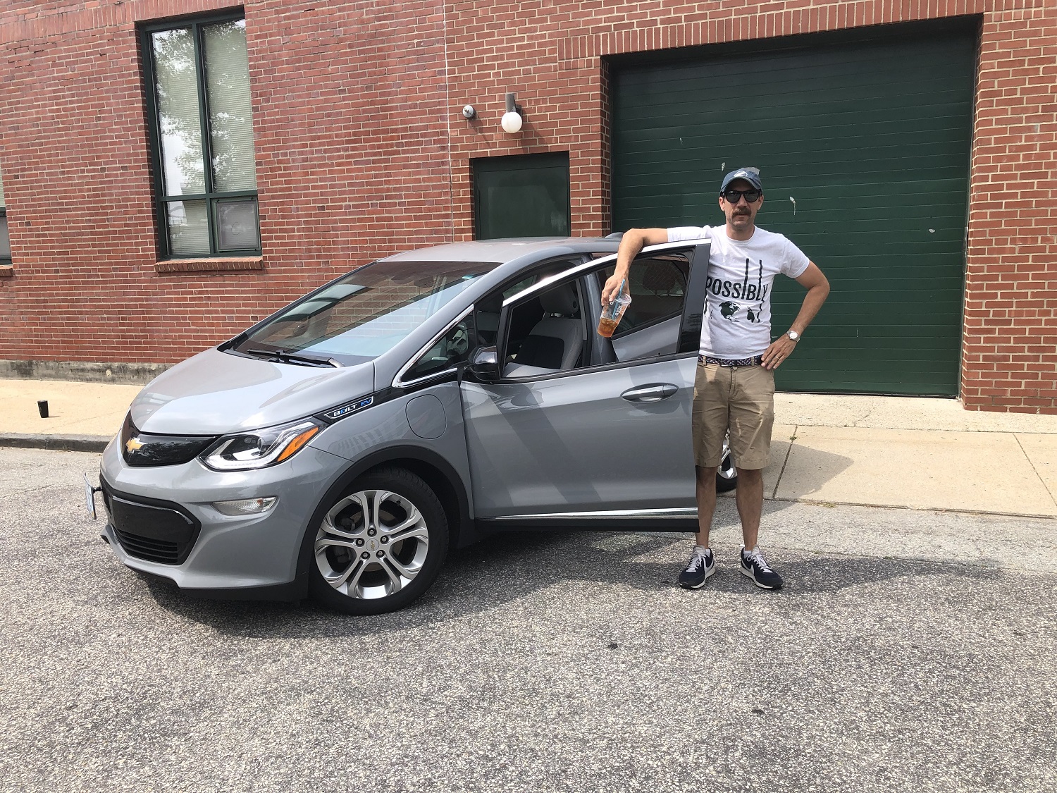 Ryan T Conaty in front of his EV