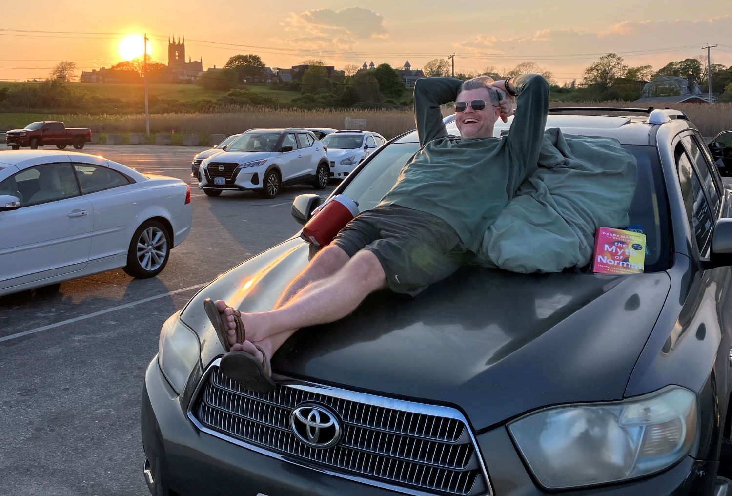 Jeffrey Marcus stretches out on the roof of his SUV after an afternoon at Surfers End at Sachuest Beach in Middletown, on May 11, 2023.