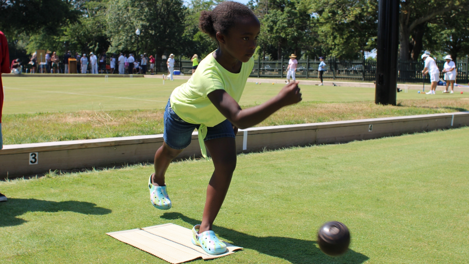 A young South End resident plays a game of lawn bowling at Hazelwood Park's newly reopened greens.