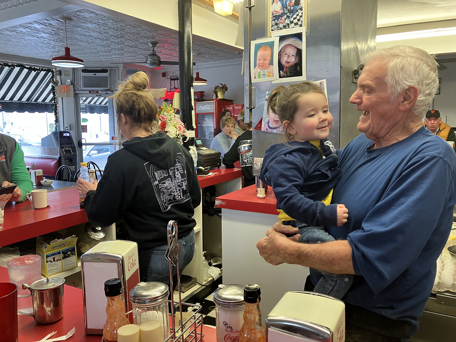 Gary Hooks, right, hugs his great granddaughter, Avery, behind the counter at Gary's Handy Lunch on its last day of service on Sunday, Feb. 12, 2023. Family and friends gathered at the beloved diner to mark the end of more than 55 years of service.