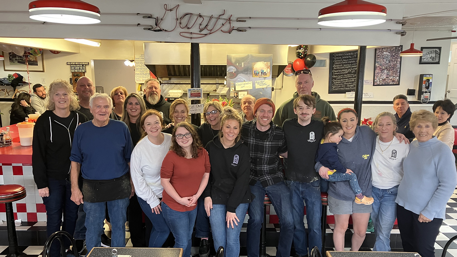 Gary Hooks, second from left, and his wife, Mary, far right, pose for a group portrait with family and friends after their diner, Gary's Handy Lunch closed its doors for the last time on Feb. 12, 2023. Gary's Handy lunch was a beloved diner in downtown Newport.