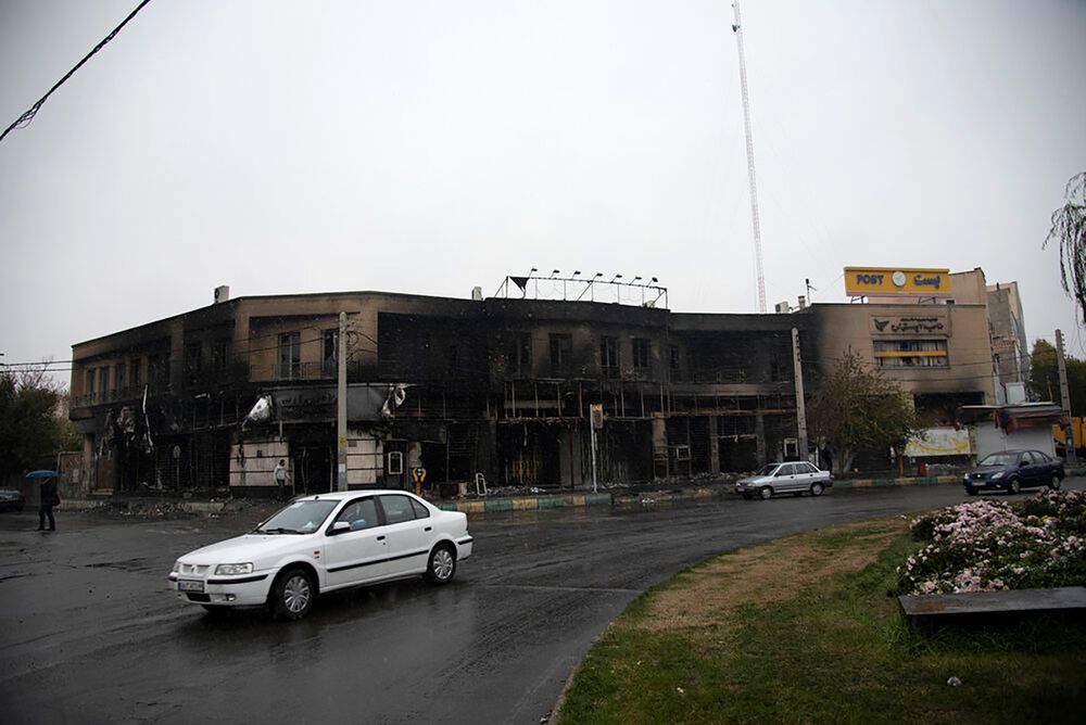 In this photo taken Monday, Nov. 18, 2019, and released by the Iranian Students' News Agency, ISNA, cars drive past a building which burned during protests that followed the authorities' decision to raise gasoline prices, in the city of Karaj, west of the capital Tehran, Iran. An article published Tuesday in Keyhan, a hard-line newspaper in Iran suggested that those who led violent protests will be executed by hanging as the unrest continues. (Masoume Aliakbar/ISNA via AP) In this photo taken Monday, Nov. 18, 2019, and released by the Iranian Students' News Agency, ISNA, cars drive past a building which burned during protests that followed the authorities' decision to raise gasoline prices, in the city of Karaj, west of the capital Tehran, Iran. An article published Tuesday in Keyhan, a hard-line newspaper in Iran suggested that those who led violent protests will be executed by hanging as the unrest continues. (Masoume Aliakbar/ISNA via AP)