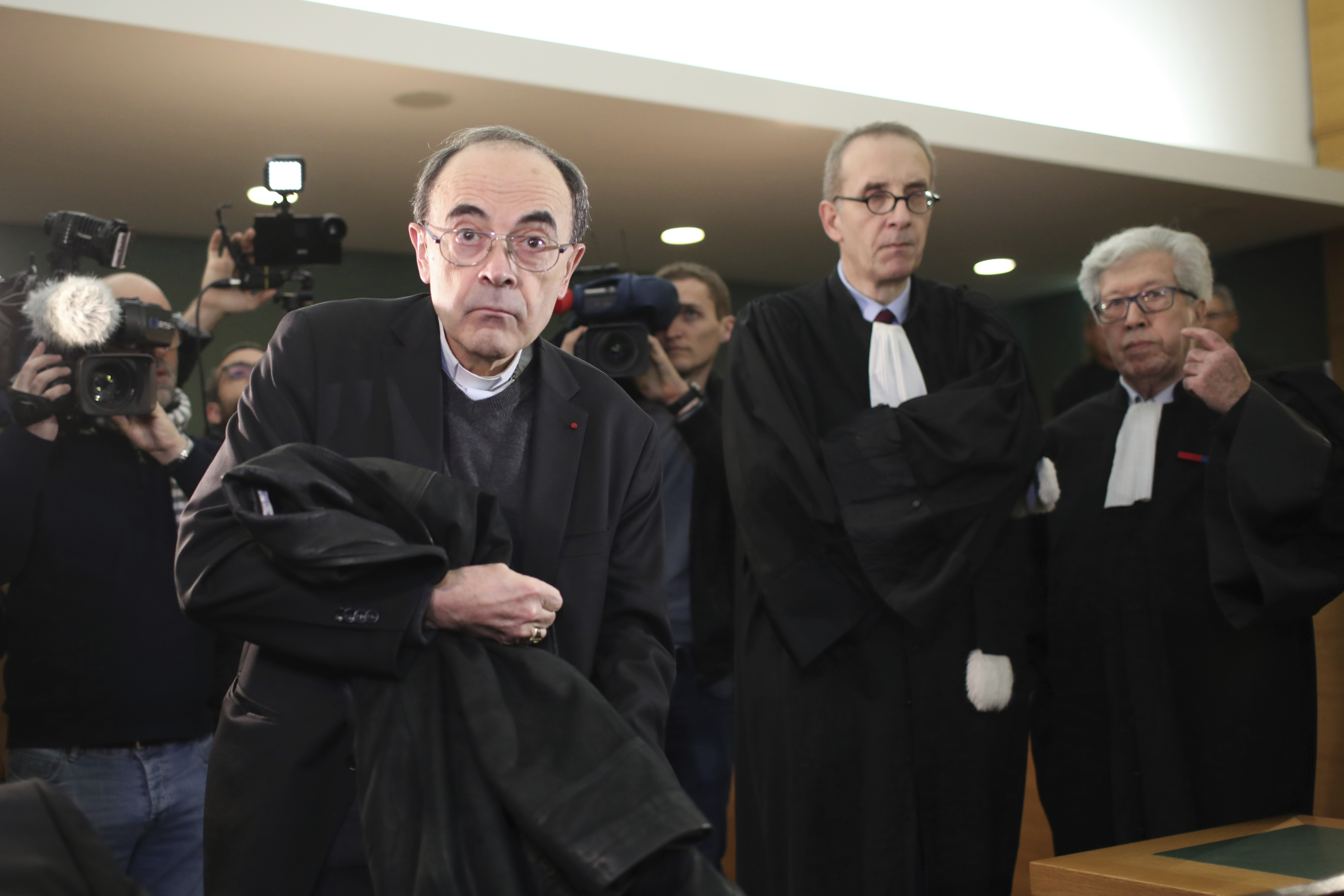 FILE - In this Jan.7, 2019 file photo, cardinal Philippe Barbarin, center, takes his seat as he arrives at the Lyon courthouse with his lawyers : Jean-Felix Luciani, 2nd right, and Andre Soulier, right, to attend his trial, in Lyon, central France. Still coming to terms with their responsibility in the clerical sex abuse scandals that have rocked the Catholic church, French bishops have finally accepted the principle of awarding a financial compensation to victims in France. (AP Photo/Laurent Cipriani, File) FILE - In this Jan.7, 2019 file photo, cardinal Philippe Barbarin, center, takes his seat as he arrives at the Lyon courthouse with his lawyers : Jean-Felix Luciani, 2nd right, and Andre Soulier, right, to attend his trial, in Lyon, central France. Still coming to terms with their responsibility in the clerical sex abuse scandals that have rocked the Catholic church, French bishops have finally accepted the principle of awarding a financial compensation to victims in France. (AP Photo/Laurent Cipriani, File)