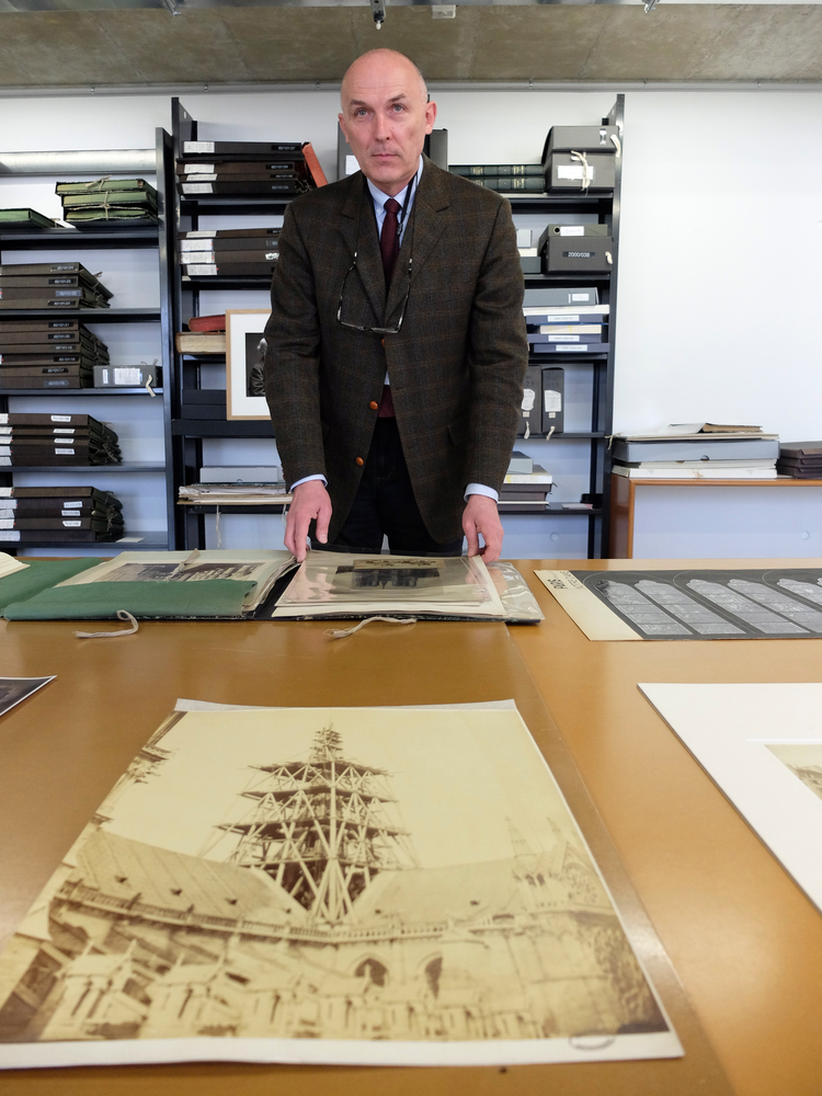 Jean-Charles Forgeret poses with archives documents related to Notre Dame cathedral in Charenton le Pont, outside Paris, Thursday, April 18, 2019. The reconstruction of Paris' Notre Dame Cathedral will rely on part on extensive plans drawn up in the 19th century for its last big renovation. Forgeret noted that the last restoration took 20 years, and cast doubt on the French president's 5-year deadline on fixing Notre Dame this time. (AP Photo/Nicolas Garriga) Jean-Charles Forgeret poses with archives documents related to Notre Dame cathedral in Charenton le Pont, outside Paris, Thursday, April 18, 2019. The reconstruction of Paris' Notre Dame Cathedral will rely on part on extensive plans drawn up in the 19th century for its last big renovation. Forgeret noted that the last restoration took 20 years, and cast doubt on the French president's 5-year deadline on fixing Notre Dame this time. (AP Photo/Nicolas Garriga)