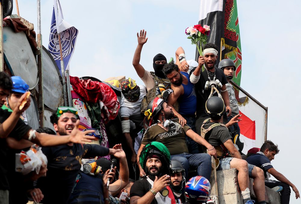 Anti-government protesters stand on barriers set by Iraqi security forces to close the Joumhouriya bridge leading to the Green Zone government areas during ongoing protests in Baghdad, Iraq, Sunday, Nov. 3, 2019. (AP Photo/Hadi Mizban) Anti-government protesters stand on barriers set by Iraqi security forces to close the Joumhouriya bridge leading to the Green Zone government areas during ongoing protests in Baghdad, Iraq, Sunday, Nov. 3, 2019. (AP Photo/Hadi Mizban)