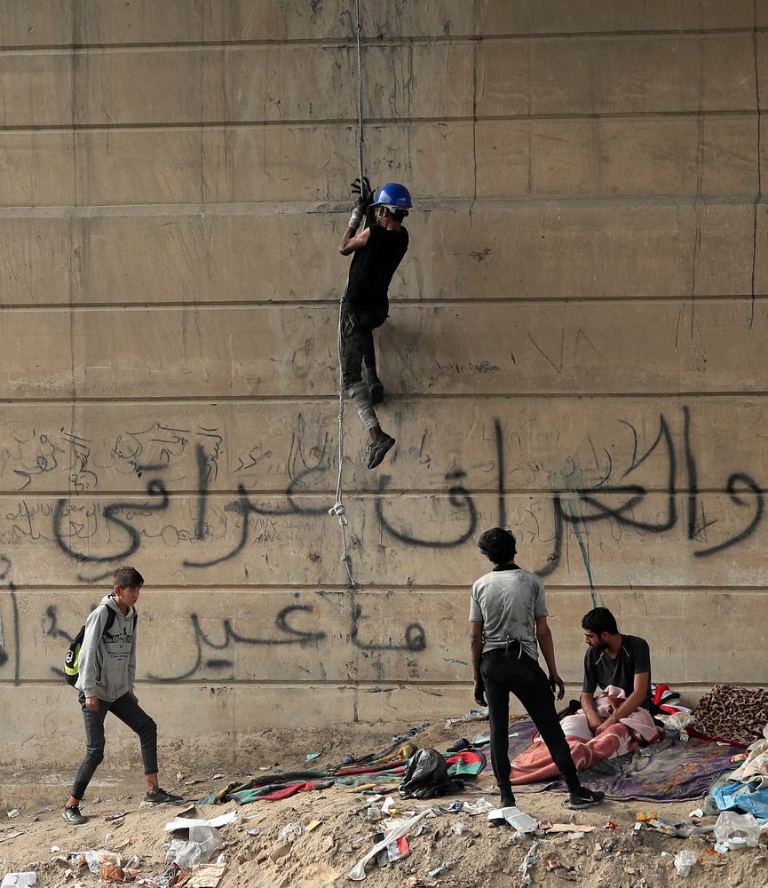 An anti-government protester climbs the Joumhouriya Bridge that leads to the Green Zone government area, during ongoing protests in Baghdad, Iraq, Sunday, Nov. 3, 2019. Arabic reads, “Iraq is Iraqi.” (AP Photo/Hadi Mizban) An anti-government protester climbs the Joumhouriya Bridge that leads to the Green Zone government area, during ongoing protests in Baghdad, Iraq, Sunday, Nov. 3, 2019. Arabic reads, “Iraq is Iraqi.” (AP Photo/Hadi Mizban)