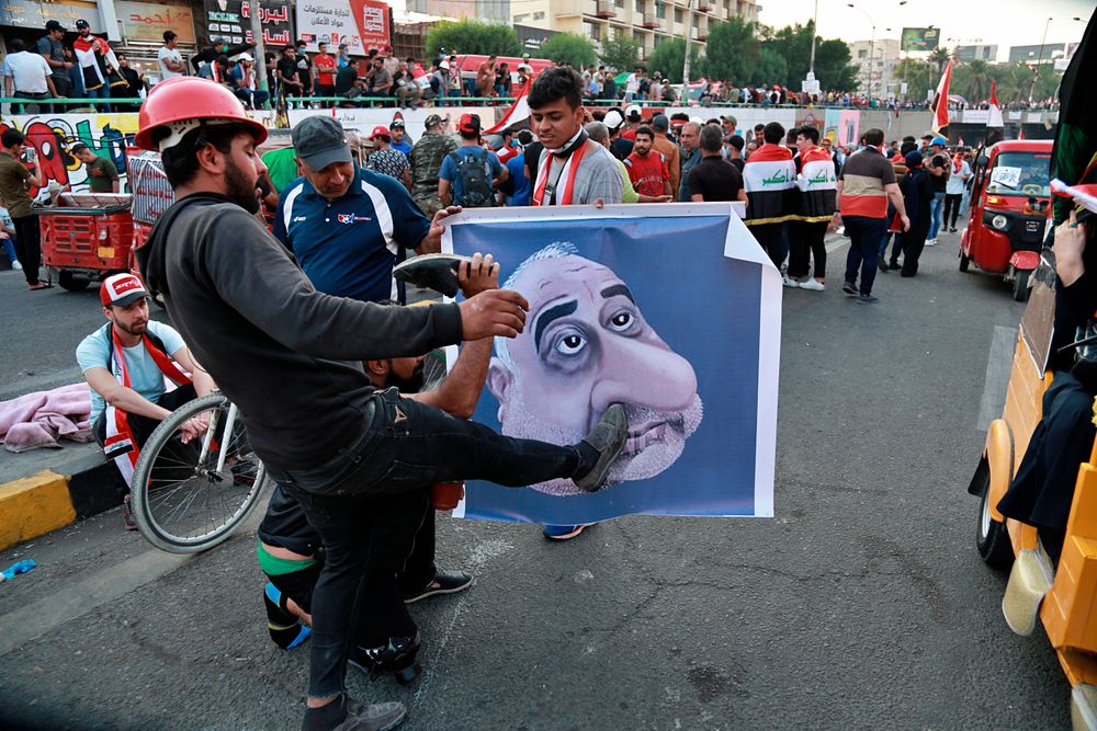 Protesters hit a poster showing Iraqi Prime Minister Adel Abdel-Mahdi with shoes during ongoing anti-government protests in Baghdad, Iraq, Sunday, Nov. 3, 2019. (AP Photo) Protesters hit a poster showing Iraqi Prime Minister Adel Abdel-Mahdi with shoes during ongoing anti-government protests in Baghdad, Iraq, Sunday, Nov. 3, 2019. (AP Photo)