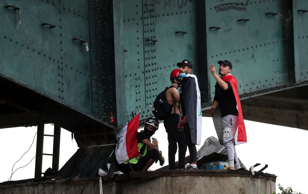 Protesters stand under the Joumhouriya Bridge, that lead to the Green Zone where many government offices and embassies are located, during ongoing anti-government protests in Baghdad, Iraq, Sunday, Nov. 3, 2019. (AP Photo/Hadi Mizban) Protesters stand under the Joumhouriya Bridge, that lead to the Green Zone where many government offices and embassies are located, during ongoing anti-government protests in Baghdad, Iraq, Sunday, Nov. 3, 2019. (AP Photo/Hadi Mizban)