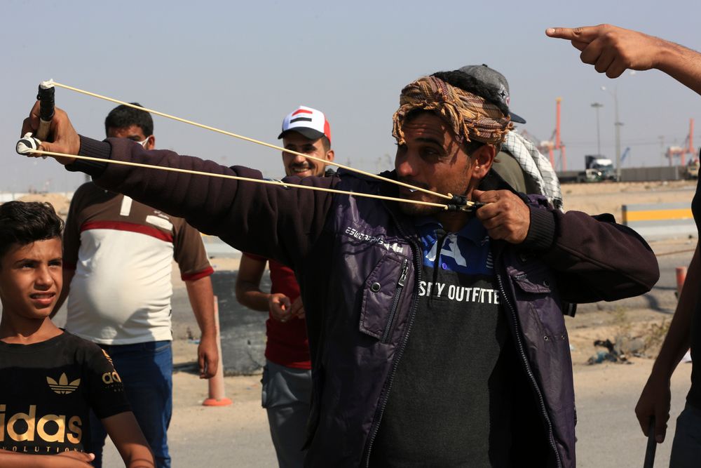 An anti-government protester fires a slingshot as they block the port of Umm Qasr during ongoing anti-government protests, in Basra, Iraq, Sunday, Nov. 3, 2019. (AP Photo/Nabil al-Jourani) An anti-government protester fires a slingshot as they block the port of Umm Qasr during ongoing anti-government protests, in Basra, Iraq, Sunday, Nov. 3, 2019. (AP Photo/Nabil al-Jourani)