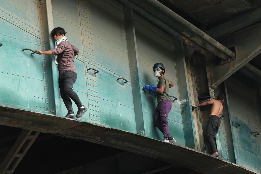 Anti-government protesters climb the Joumhouriya Bridge that leads to the Green Zone government area, during ongoing protests in Baghdad, Iraq, Sunday, Nov. 3, 2019. (AP Photo/Hadi Mizban) Anti-government protesters climb the Joumhouriya Bridge that leads to the Green Zone government area, during ongoing protests in Baghdad, Iraq, Sunday, Nov. 3, 2019. (AP Photo/Hadi Mizban)