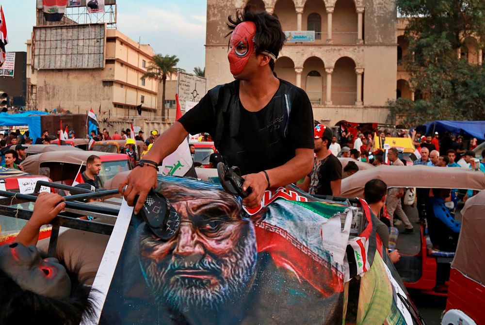 A protester hits a poster showing the leader of the Iranian Revolutionary Guard's foreign wing, or Quds Force, Gen. Qassim Soleimani with a shoe during ongoing anti-government protests in Baghdad, Iraq, Sunday, Nov. 3, 2019. (AP Photo) A protester hits a poster showing the leader of the Iranian Revolutionary Guard's foreign wing, or Quds Force, Gen. Qassim Soleimani with a shoe during ongoing anti-government protests in Baghdad, Iraq, Sunday, Nov. 3, 2019. (AP Photo)
