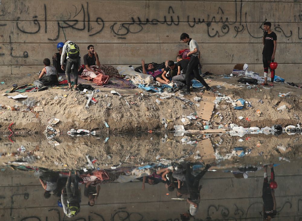 Protesters rest under the Joumhouriya Bridge, that leads to the Green Zone where many government offices and embassies are located, during ongoing anti-government protests, in Baghdad, Iraq, Sunday, Nov. 3, 2019. (AP Photo/Hadi Mizban) Protesters rest under the Joumhouriya Bridge, that leads to the Green Zone where many government offices and embassies are located, during ongoing anti-government protests, in Baghdad, Iraq, Sunday, Nov. 3, 2019. (AP Photo/Hadi Mizban)