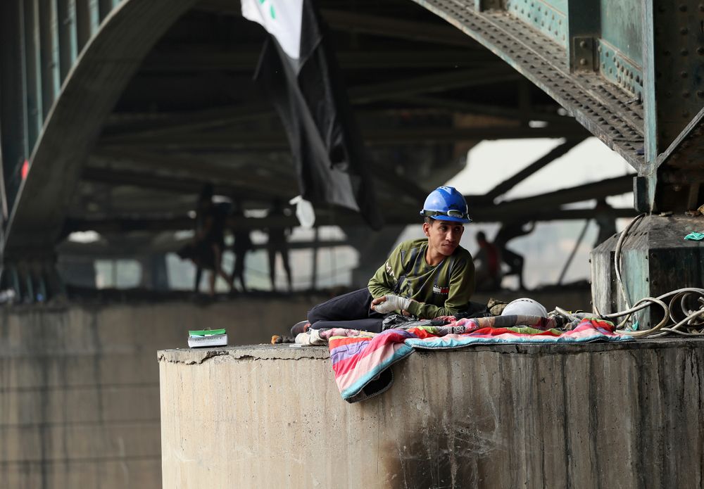 A protesters rest under the Joumhouriya Bridge, that leads to the Green Zone where many government offices and embassies are located, during ongoing anti-government protests, in Baghdad, Iraq, Sunday, Nov. 3, 2019. (AP Photo/Hadi Mizban) A protesters rest under the Joumhouriya Bridge, that leads to the Green Zone where many government offices and embassies are located, during ongoing anti-government protests, in Baghdad, Iraq, Sunday, Nov. 3, 2019. (AP Photo/Hadi Mizban)