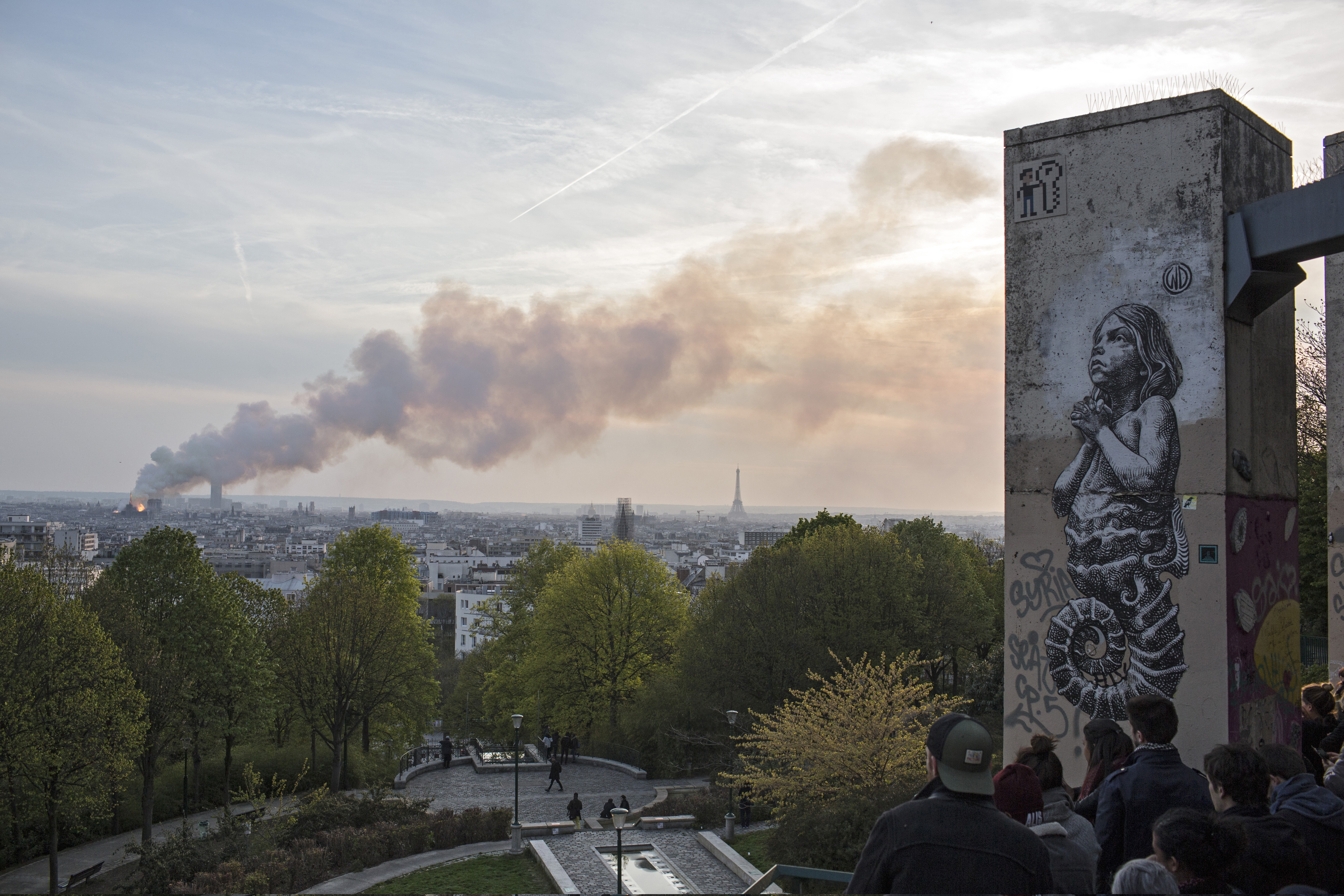 People watch Notre Dame cathedral burning in Paris, Monday, April 15, 2019. Massive plumes of yellow brown smoke is filling the air above Notre Dame Cathedral and ash is falling on tourists and others around the island that marks the center of Paris. (AP Photo/Rafael Yaghobzadeh) People watch Notre Dame cathedral burning in Paris, Monday, April 15, 2019. Massive plumes of yellow brown smoke is filling the air above Notre Dame Cathedral and ash is falling on tourists and others around the island that marks the center of Paris. (AP Photo/Rafael Yaghobzadeh)