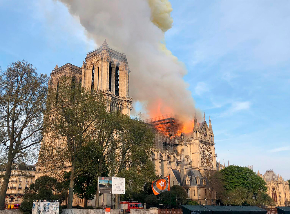 Notre Dame cathedral is burning in Paris, Monday, April 15, 2019. Massive plumes of yellow brown smoke is filling the air above Notre Dame Cathedral and ash is falling on tourists and others around the island that marks the center of Paris. (AP Photo) Notre Dame cathedral is burning in Paris, Monday, April 15, 2019. Massive plumes of yellow brown smoke is filling the air above Notre Dame Cathedral and ash is falling on tourists and others around the island that marks the center of Paris. (AP Photo)