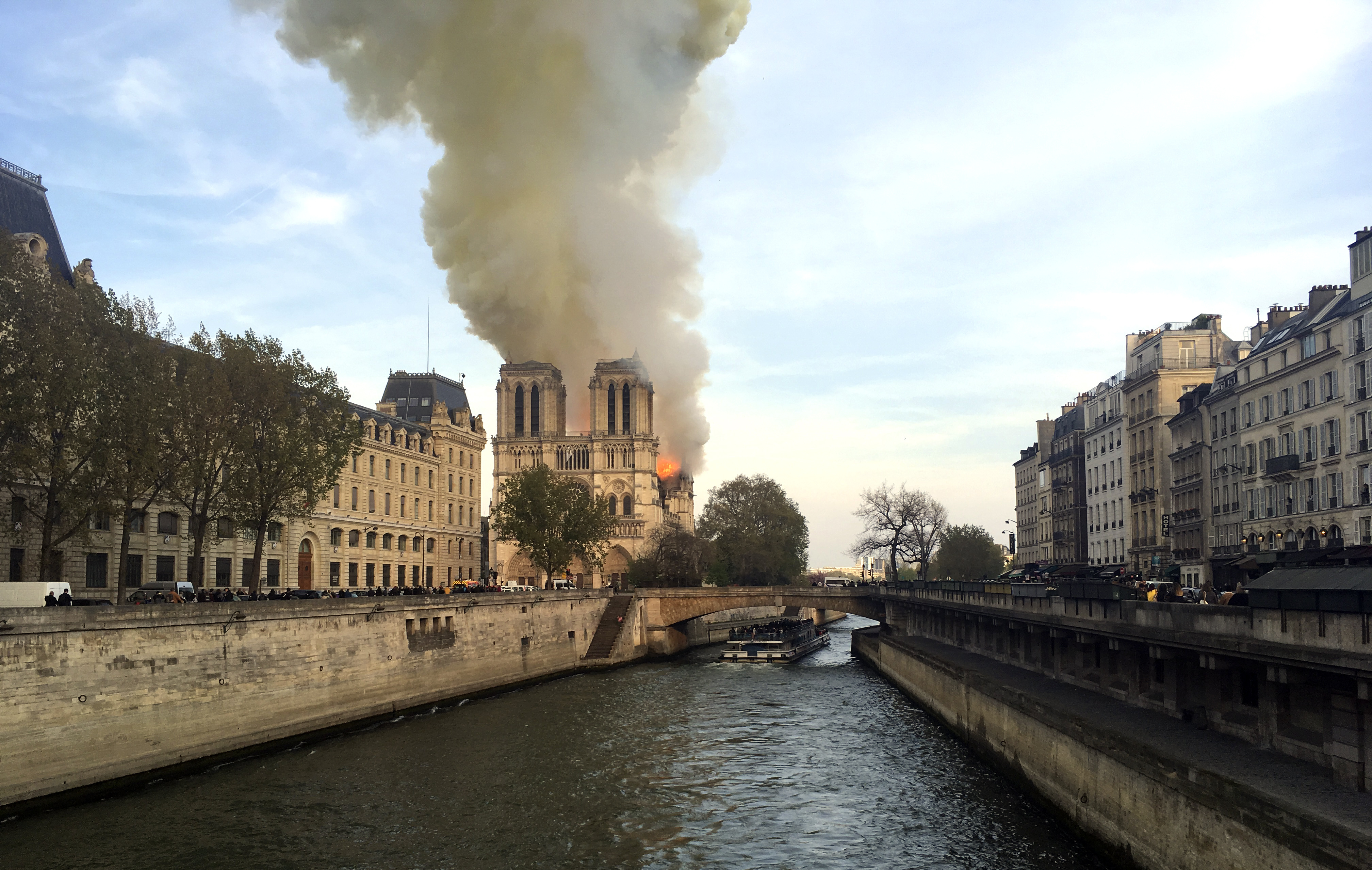 Notre Dame cathedral is burning in Paris, Monday, April 15, 2019. Massive plumes of yellow brown smoke is filling the air above Notre Dame Cathedral and ash is falling on tourists and others around the island that marks the center of Paris. (AP Photo/Lori Hinant) Notre Dame cathedral is burning in Paris, Monday, April 15, 2019. Massive plumes of yellow brown smoke is filling the air above Notre Dame Cathedral and ash is falling on tourists and others around the island that marks the center of Paris. (AP Photo/Lori Hinant)