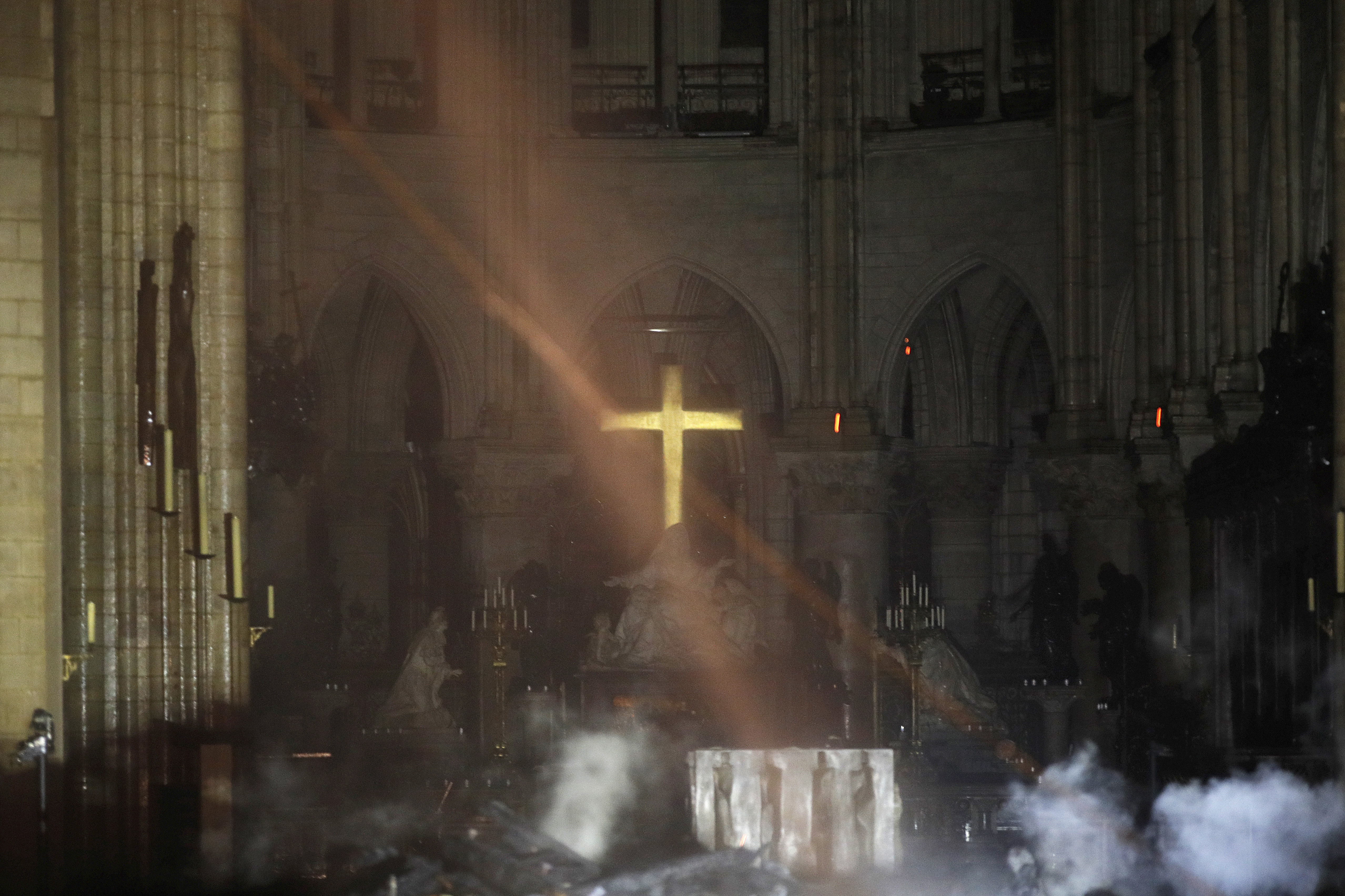 Smoke is seen around the alter inside Notre Dame cathedral in Paris, Monday, April 15, 2019. A catastrophic fire engulfed the upper reaches of Paris' soaring Notre Dame Cathedral as it was undergoing renovations Monday, threatening one of the greatest architectural treasures of the Western world as tourists and Parisians looked on aghast from the streets below. (Philippe Wojazer/Pool via AP) Smoke is seen around the alter inside Notre Dame cathedral in Paris, Monday, April 15, 2019. A catastrophic fire engulfed the upper reaches of Paris' soaring Notre Dame Cathedral as it was undergoing renovations Monday, threatening one of the greatest architectural treasures of the Western world as tourists and Parisians looked on aghast from the streets below. (Philippe Wojazer/Pool via AP)