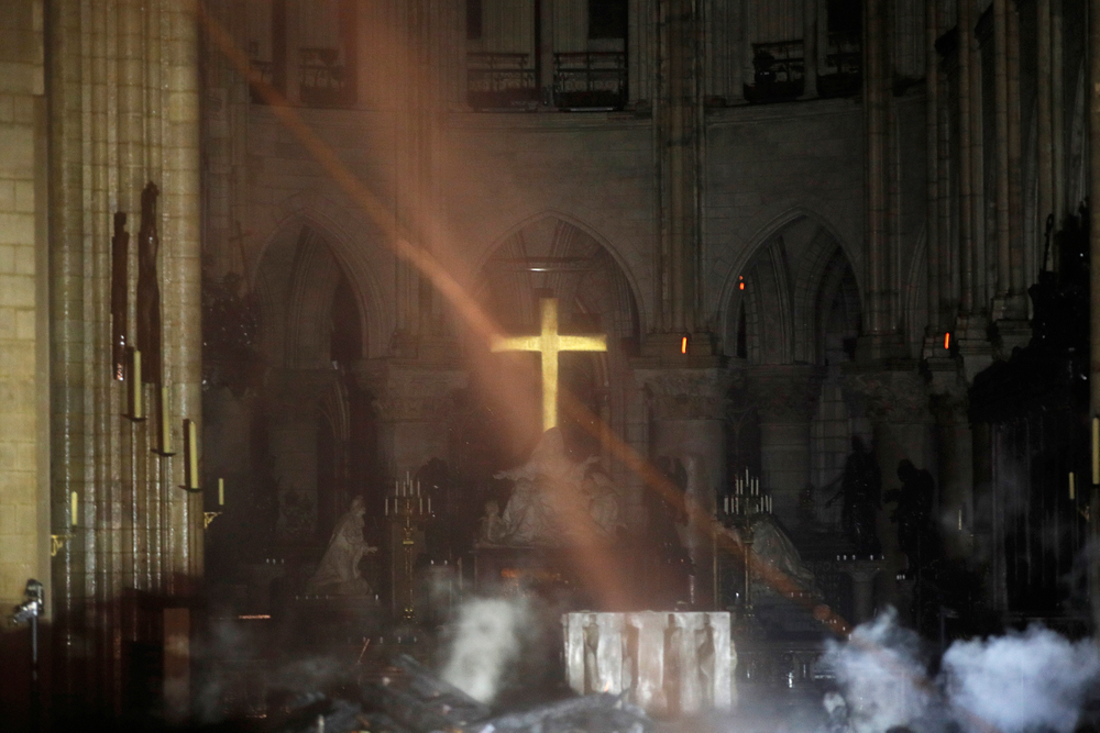 Smoke is seen around the alter inside Notre Dame cathedral in Paris, Monday, April 15, 2019. A catastrophic fire engulfed the upper reaches of Paris' soaring Notre Dame Cathedral as it was undergoing renovations Monday, threatening one of the greatest architectural treasures of the Western world as tourists and Parisians looked on aghast from the streets below. (Philippe Wojazer/Pool via AP) Smoke is seen around the alter inside Notre Dame cathedral in Paris, Monday, April 15, 2019. A catastrophic fire engulfed the upper reaches of Paris' soaring Notre Dame Cathedral as it was undergoing renovations Monday, threatening one of the greatest architectural treasures of the Western world as tourists and Parisians looked on aghast from the streets below. (Philippe Wojazer/Pool via AP)