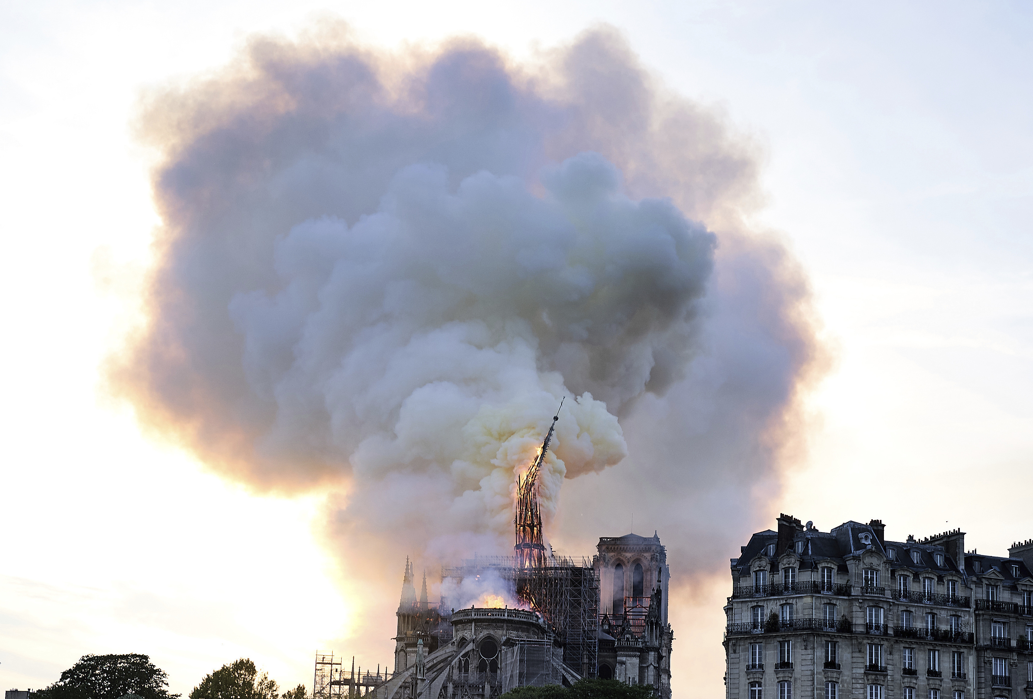Flames and smoke rise as the spire on Notre Dame cathedral collapses in Paris, Monday, April 15, 2019. Massive plumes of yellow brown smoke is filling the air above Notre Dame Cathedral and ash is falling on tourists and others around the island that marks the center of Paris. (AP Photo/Diana Ayanna) Flames and smoke rise as the spire on Notre Dame cathedral collapses in Paris, Monday, April 15, 2019. Massive plumes of yellow brown smoke is filling the air above Notre Dame Cathedral and ash is falling on tourists and others around the island that marks the center of Paris. (AP Photo/Diana Ayanna)