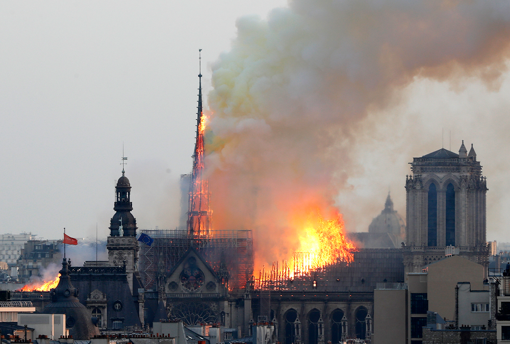 Flames rise from Notre Dame cathedral as it burns in Paris, Monday, April 15, 2019. Massive plumes of yellow brown smoke is filling the air above Notre Dame Cathedral and ash is falling on tourists and others around the island that marks the center of Paris. (AP Photo/Thibault Camus) Flames rise from Notre Dame cathedral as it burns in Paris, Monday, April 15, 2019. Massive plumes of yellow brown smoke is filling the air above Notre Dame Cathedral and ash is falling on tourists and others around the island that marks the center of Paris. (AP Photo/Thibault Camus)