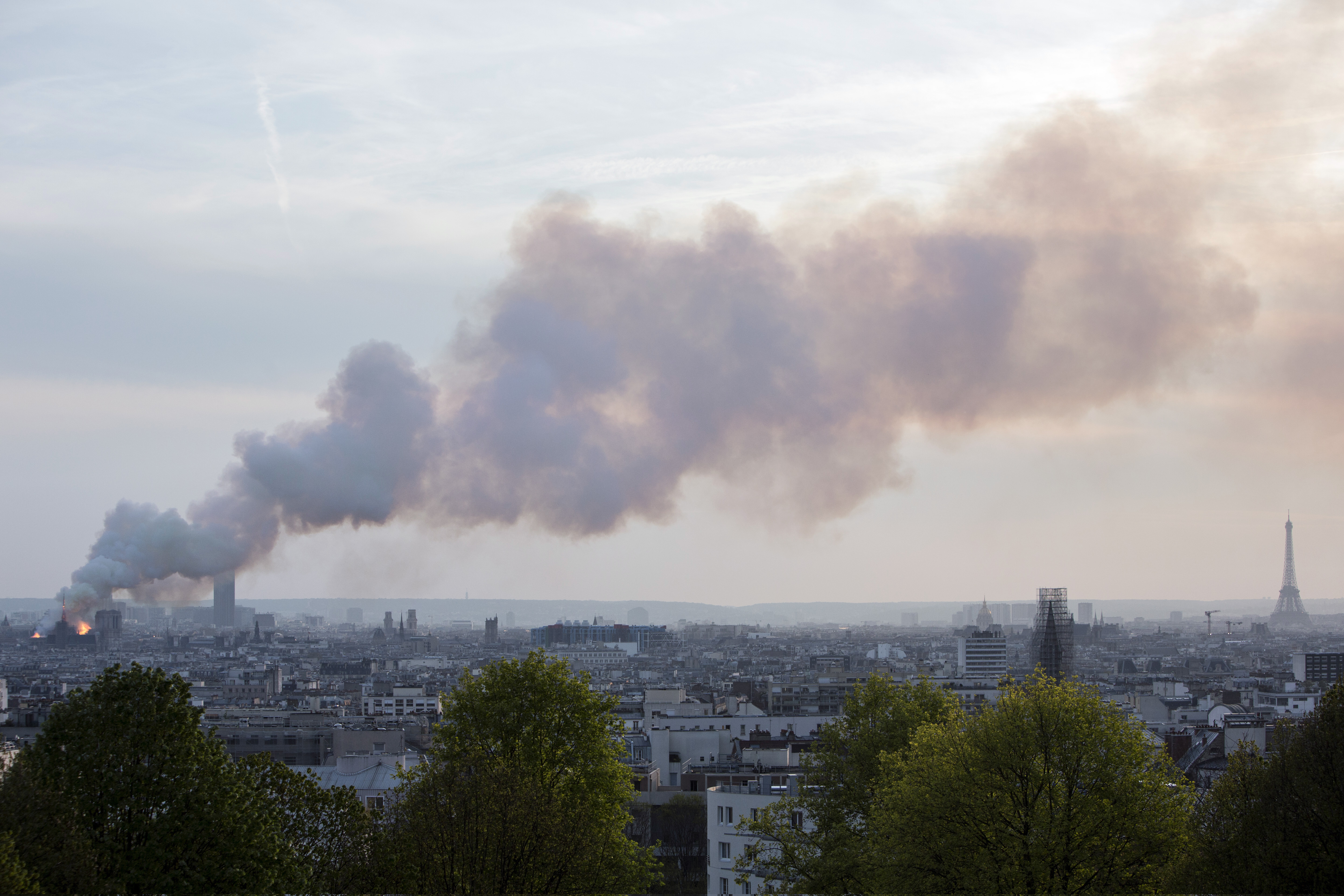 Smoke fill the air as Notre Dame cathedral is burning in Paris, Monday, April 15, 2019. Massive plumes of yellow brown smoke is filling the air above Notre Dame Cathedral and ash is falling on tourists and others around the island that marks the center of Paris. (AP Photo/Rafael Yaghobzadeh) Smoke fill the air as Notre Dame cathedral is burning in Paris, Monday, April 15, 2019. Massive plumes of yellow brown smoke is filling the air above Notre Dame Cathedral and ash is falling on tourists and others around the island that marks the center of Paris. (AP Photo/Rafael Yaghobzadeh)