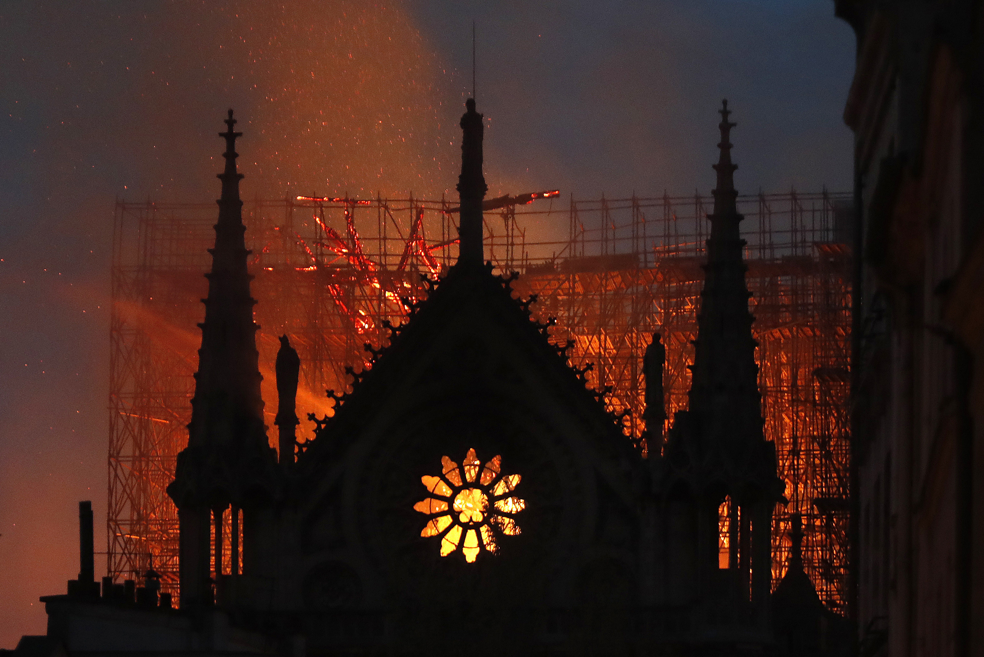 Flames and smoke rise from Notre Dame cathedral as it burns in Paris, Monday, April 15, 2019. Massive plumes of yellow brown smoke is filling the air above Notre Dame Cathedral and ash is falling on tourists and others around the island that marks the center of Paris. (AP Photo/Thibault Camus) Flames and smoke rise from Notre Dame cathedral as it burns in Paris, Monday, April 15, 2019. Massive plumes of yellow brown smoke is filling the air above Notre Dame Cathedral and ash is falling on tourists and others around the island that marks the center of Paris. (AP Photo/Thibault Camus)