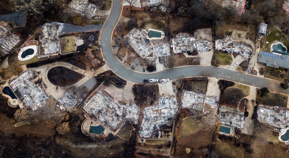 FILE - This Dec. 3, 2018, file photo, shows homes leveled by the Camp Fire line Valley Ridge Drive in Paradise, Calif. Attorneys representing 14 local governments said Tuesday, June 18, 2019, that they had reached a $1 billion settlement with California utility Pacific Gas & Electric for a series of fires dating to 2015. (AP Photo/Noah Berger, File) FILE - This Dec. 3, 2018, file photo, shows homes leveled by the Camp Fire line Valley Ridge Drive in Paradise, Calif. Attorneys representing 14 local governments said Tuesday, June 18, 2019, that they had reached a $1 billion settlement with California utility Pacific Gas & Electric for a series of fires dating to 2015. (AP Photo/Noah Berger, File)