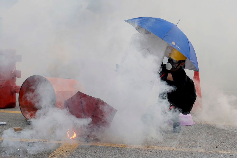 A protester is shrouded by tear gas in Hong Kong, Monday, Aug. 5, 2019. Droves of protesters filled public parks and squares in several Hong Kong districts on Monday in a general strike staged on a weekday to draw more attention to their demands that the semi-autonomous Chinese city's leader resign.(AP Photo/Kin Cheung) A protester is shrouded by tear gas in Hong Kong, Monday, Aug. 5, 2019. Droves of protesters filled public parks and squares in several Hong Kong districts on Monday in a general strike staged on a weekday to draw more attention to their demands that the semi-autonomous Chinese city's leader resign.(AP Photo/Kin Cheung)