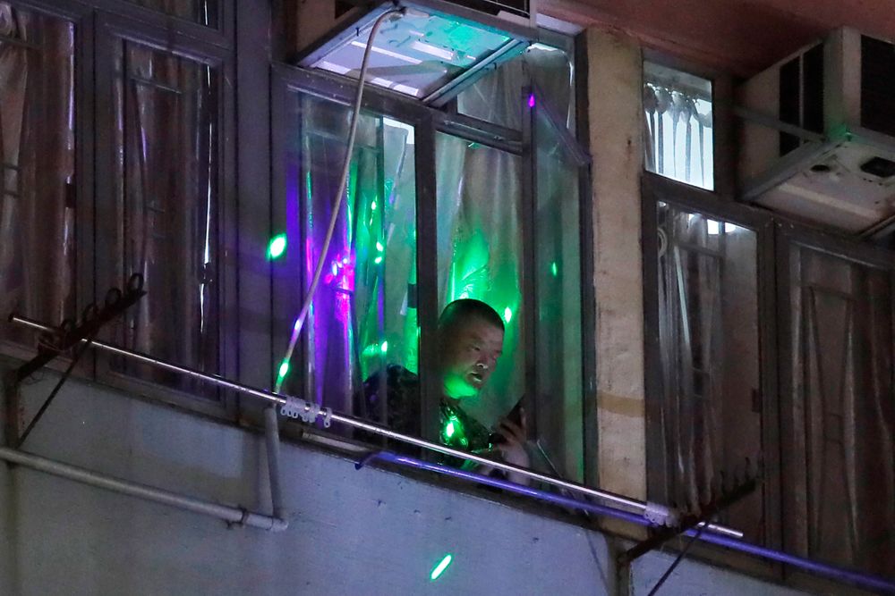 Protesters flash laser beams onto a man in a residential building as they think he is a pro-Beijing supporter in Hong Kong, Monday, Aug. 5, 2019. Droves of protesters filled public parks and squares in several Hong Kong districts on Monday in a general strike staged on a weekday to draw more attention to their demands that the semi-autonomous Chinese city's leader resign.(AP Photo/Kin Cheung) Protesters flash laser beams onto a man in a residential building as they think he is a pro-Beijing supporter in Hong Kong, Monday, Aug. 5, 2019. Droves of protesters filled public parks and squares in several Hong Kong districts on Monday in a general strike staged on a weekday to draw more attention to their demands that the semi-autonomous Chinese city's leader resign.(AP Photo/Kin Cheung)