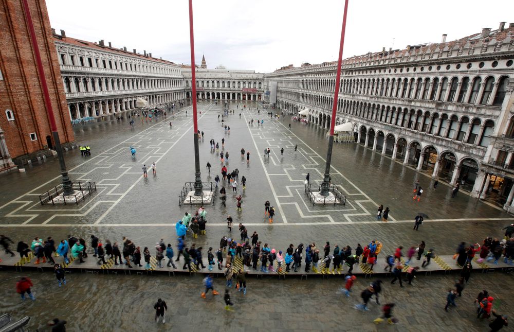 People walk in a flooded St. Mark's Square in Venice, Italy, Tuesday, Nov. 12, 2019. The high tide reached a peak of 127cm (4.1ft) at 10:35am while an even higher level of 140cm(4.6ft) was predicted for later Tuesday evening. (AP Photo/Luca Bruno) People walk in a flooded St. Mark's Square in Venice, Italy, Tuesday, Nov. 12, 2019. The high tide reached a peak of 127cm (4.1ft) at 10:35am while an even higher level of 140cm(4.6ft) was predicted for later Tuesday evening. (AP Photo/Luca Bruno)