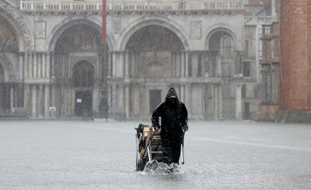 A greengrocer carries his cart as the water begins to flood St. Mark's Square on the occasion of a high tide, in Venice, Italy, Tuesday, Nov. 12, 2019. The high tide reached a peak of 127cm (4.1ft) at 10:35am while an even higher level of 140cm(4.6ft) was predicted for later Tuesday evening. (AP Photo/Luca Bruno) A greengrocer carries his cart as the water begins to flood St. Mark's Square on the occasion of a high tide, in Venice, Italy, Tuesday, Nov. 12, 2019. The high tide reached a peak of 127cm (4.1ft) at 10:35am while an even higher level of 140cm(4.6ft) was predicted for later Tuesday evening. (AP Photo/Luca Bruno)