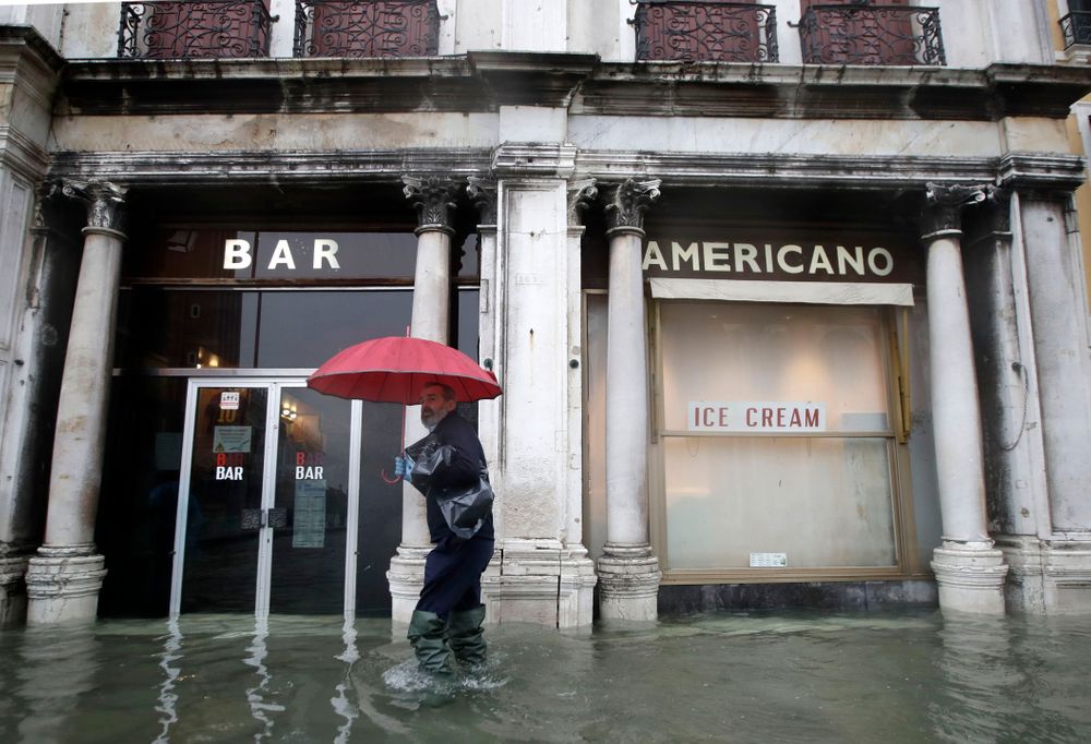 A man walks past a closed cafe in a flooded Venice, Italy, Tuesday, Nov. 12, 2019. The high tide reached a peak of 127cm (4.1ft) at 10:35am while an even higher level of 140cm(4.6ft) was predicted for later Tuesday evening. (AP Photo/Luca Bruno) A man walks past a closed cafe in a flooded Venice, Italy, Tuesday, Nov. 12, 2019. The high tide reached a peak of 127cm (4.1ft) at 10:35am while an even higher level of 140cm(4.6ft) was predicted for later Tuesday evening. (AP Photo/Luca Bruno)