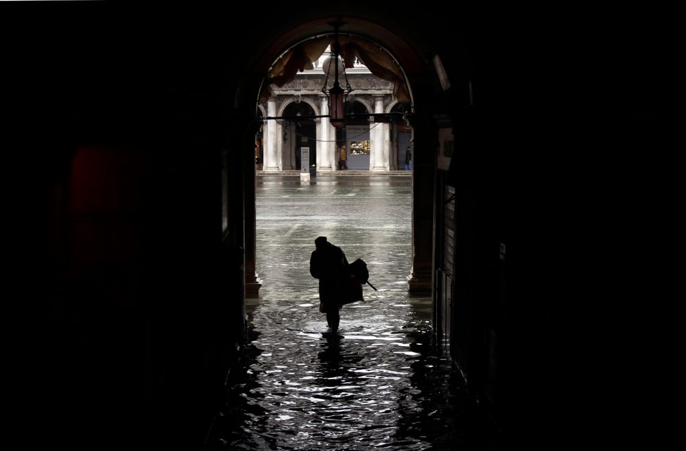 A woman is silhouetted as she walks towards a flooded St. Mark's Square, on the occasion of a high tide, in Venice, Italy, Tuesday, Nov. 12, 2019. The high tide reached a peak of 127cm (4.1ft) at 10:35am while an even higher level of 140cm(4.6ft) was predicted for later Tuesday evening. (AP Photo/Luca Bruno) A woman is silhouetted as she walks towards a flooded St. Mark's Square, on the occasion of a high tide, in Venice, Italy, Tuesday, Nov. 12, 2019. The high tide reached a peak of 127cm (4.1ft) at 10:35am while an even higher level of 140cm(4.6ft) was predicted for later Tuesday evening. (AP Photo/Luca Bruno)