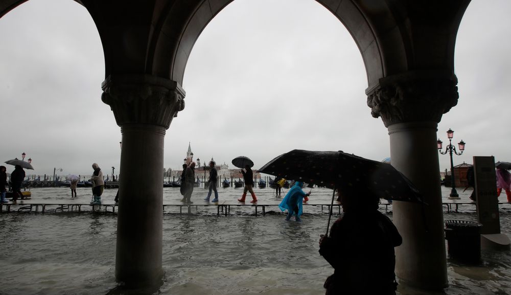 People walk on catwalk set up on the occasion of a high tide, in a flooded Venice, Italy, Tuesday, Nov. 12, 2019. The high tide reached a peak of 127cm (4.1ft) at 10:35am while an even higher level of 140cm(4.6ft) was predicted for later Tuesday evening. (AP Photo/Luca Bruno) People walk on catwalk set up on the occasion of a high tide, in a flooded Venice, Italy, Tuesday, Nov. 12, 2019. The high tide reached a peak of 127cm (4.1ft) at 10:35am while an even higher level of 140cm(4.6ft) was predicted for later Tuesday evening. (AP Photo/Luca Bruno)