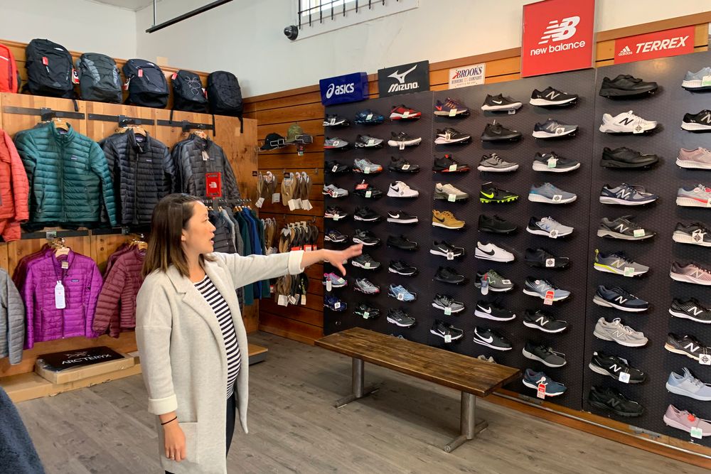 In this photo taken Wednesday, Aug. 28, 2019, Jennifer Lee, whose family owns Footprint shoe store in San Francisco, points to a wall of athletic shoes, many of which are made in China and will be subject to new U.S. tariffs on Chinese goods starting Sept 1. (AP Photo/Terry Chea) In this photo taken Wednesday, Aug. 28, 2019, Jennifer Lee, whose family owns Footprint shoe store in San Francisco, points to a wall of athletic shoes, many of which are made in China and will be subject to new U.S. tariffs on Chinese goods starting Sept 1. (AP Photo/Terry Chea)