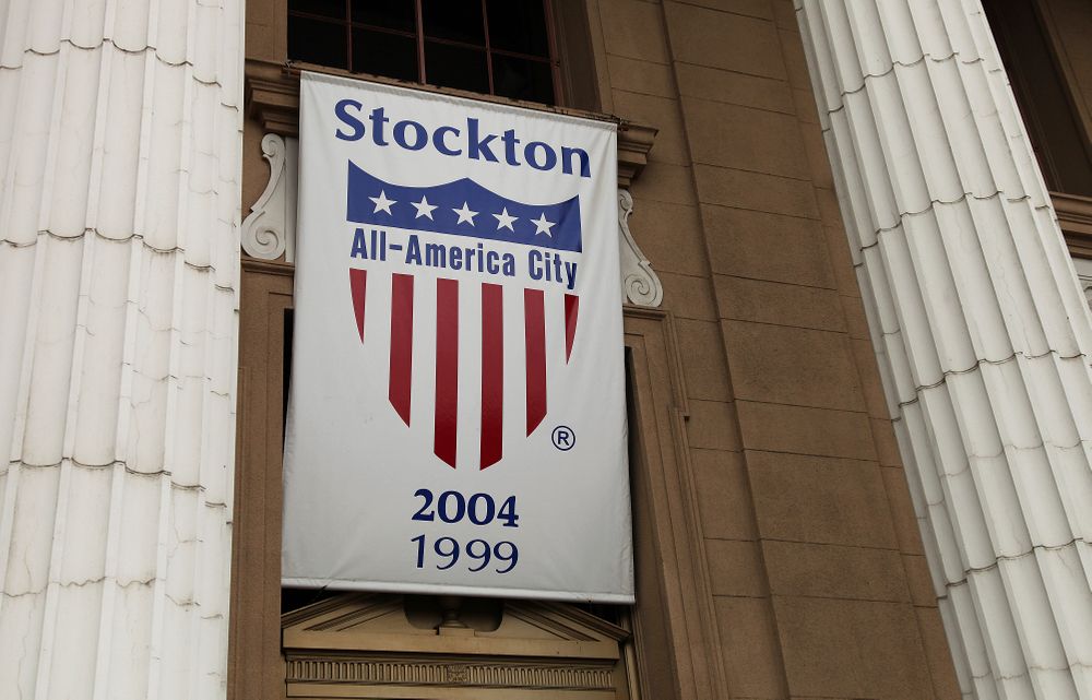 File - In this Feb. 29, 2012 file photo, a banner proclaiming Stockton as an All-America city hangs from city hall in Stockton, Calif. Stockton was once known as the foreclosure capital of the country and for one of the nation's largest municipal bankruptcies. Now, it's led by Mayor Michael Tubbs who has initiated a program to give 125 people who earn at or below the median household income of $46,033 receive a $500 debit card each month to spend any what they want. Tubbs says the program, which is privately funded, could be a solution to the city's poverty problem. (AP Photo/Ben Margot, file) File - In this Feb. 29, 2012 file photo, a banner proclaiming Stockton as an All-America city hangs from city hall in Stockton, Calif. Stockton was once known as the foreclosure capital of the country and for one of the nation's largest municipal bankruptcies. Now, it's led by Mayor Michael Tubbs who has initiated a program to give 125 people who earn at or below the median household income of $46,033 receive a $500 debit card each month to spend any what they want. Tubbs says the program, which is privately funded, could be a solution to the city's poverty problem. (AP Photo/Ben Margot, file)