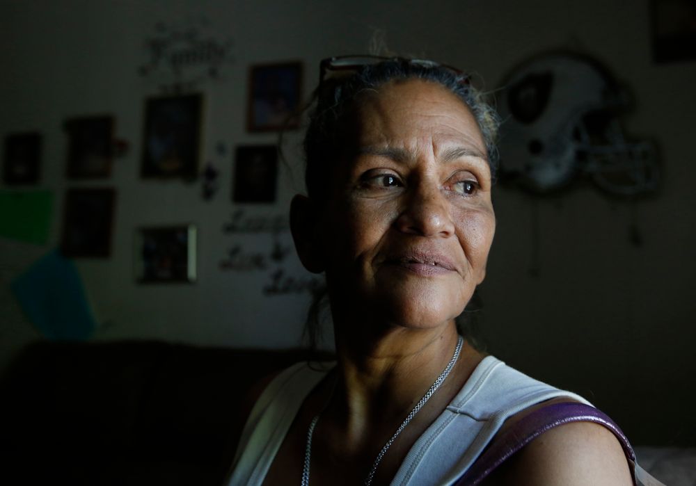 In this photo taken Wednesday, Aug. 14, 2019, Susie Garza who receives a monthly city provided debit card through a trial program, poses in her home in Stockton, Calif. Garza is participating in the Stockton Economic Empowerment Demonstration. The program, which started in February, gives $500 a month to 125 people who earn at or below the median household income of $46,033. They can spend the money with no restrictions. Stockton Mayor Michael Tubbs, who initiated the privately funded program, says it could be a solution to the city's poverty problem. (AP Photo/Rich Pedroncelli) In this photo taken Wednesday, Aug. 14, 2019, Susie Garza who receives a monthly city provided debit card through a trial program, poses in her home in Stockton, Calif. Garza is participating in the Stockton Economic Empowerment Demonstration. The program, which started in February, gives $500 a month to 125 people who earn at or below the median household income of $46,033. They can spend the money with no restrictions. Stockton Mayor Michael Tubbs, who initiated the privately funded program, says it could be a solution to the city's poverty problem. (AP Photo/Rich Pedroncelli)
