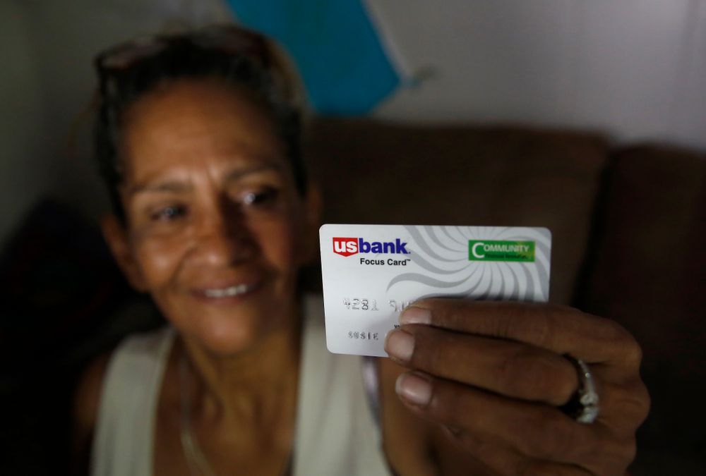 In this photo taken Wednesday, Aug. 14, 2019, Susie Garza displays the city provided debit card she receives monthly through a trial program in Stockton, Calif. Garza is participating in the Stockton Economic Empowerment Demonstration. The program, which started in February, gives $500 a month to 125 people who earn at or below the median household income of $46,033. They can spend the money with no restrictions. Stockton Mayor Michael Tubbs, who initiated the privately funded program, says it could be a solution to the city's poverty problem. (AP Photo/Rich Pedroncelli) In this photo taken Wednesday, Aug. 14, 2019, Susie Garza displays the city provided debit card she receives monthly through a trial program in Stockton, Calif. Garza is participating in the Stockton Economic Empowerment Demonstration. The program, which started in February, gives $500 a month to 125 people who earn at or below the median household income of $46,033. They can spend the money with no restrictions. Stockton Mayor Michael Tubbs, who initiated the privately funded program, says it could be a solution to the city's poverty problem. (AP Photo/Rich Pedroncelli)