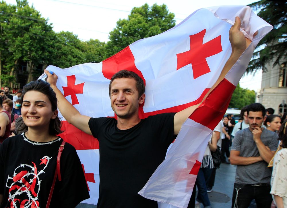 A man holds a Georgian national flags as opposition demonstrators gather in front of the Georgian Parliament building in Tbilisi, Georgia, Saturday, June 22, 2019. Demonstrators denounced the government Friday as overly friendly to Russia and calling for a snap parliamentary election. (AP Photo/Shakh Aivazov) A man holds a Georgian national flags as opposition demonstrators gather in front of the Georgian Parliament building in Tbilisi, Georgia, Saturday, June 22, 2019. Demonstrators denounced the government Friday as overly friendly to Russia and calling for a snap parliamentary election. (AP Photo/Shakh Aivazov)