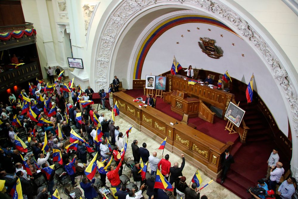 Members of the National Constituent Assembly wave Venezuelan flags during a session by the legislative body that is stacked with government allies that rivals the opposition-controlled National Assembly in Caracas, Venezuela, Monday, Aug. 12, 2019. Legislators loyal to Venezuelan President Nicolás Maduro on Monday stripped immunity from four opposition lawmakers accused of treason amid a struggle for control of the crisis-stricken nation, bringing to 18 the number of opposition politicians Maduro's government has threatened with criminal prosecution this year. (AP Photo/Leonardo Fernandez) Members of the National Constituent Assembly wave Venezuelan flags during a session by the legislative body that is stacked with government allies that rivals the opposition-controlled National Assembly in Caracas, Venezuela, Monday, Aug. 12, 2019. Legislators loyal to Venezuelan President Nicolás Maduro on Monday stripped immunity from four opposition lawmakers accused of treason amid a struggle for control of the crisis-stricken nation, bringing to 18 the number of opposition politicians Maduro's government has threatened with criminal prosecution this year. (AP Photo/Leonardo Fernandez)