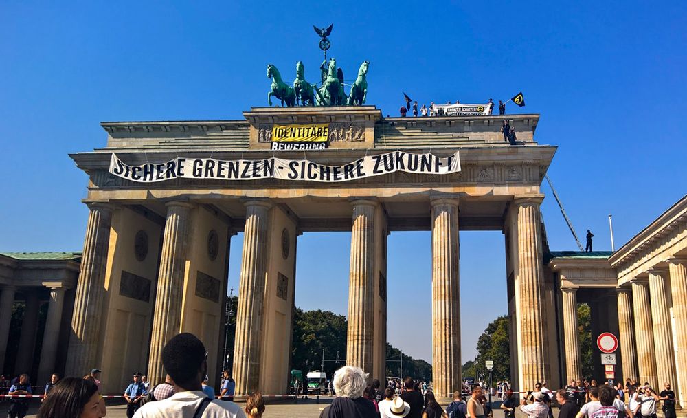 FILE - In this Aug. 27, 2016 file photo, activists of the Identitarian Movement protest on the Brandenburg Gate in Berlin, Germany, with a banner reading 'secure borders - secure future'. The German domestic intelligence agency says it is stepping up observation of the far-right Identitarian Movement in Germany that campaigns against immigrants and Islam. (AP Photo/Frank Jordans) FILE - In this Aug. 27, 2016 file photo, activists of the Identitarian Movement protest on the Brandenburg Gate in Berlin, Germany, with a banner reading 'secure borders - secure future'. The German domestic intelligence agency says it is stepping up observation of the far-right Identitarian Movement in Germany that campaigns against immigrants and Islam. (AP Photo/Frank Jordans)