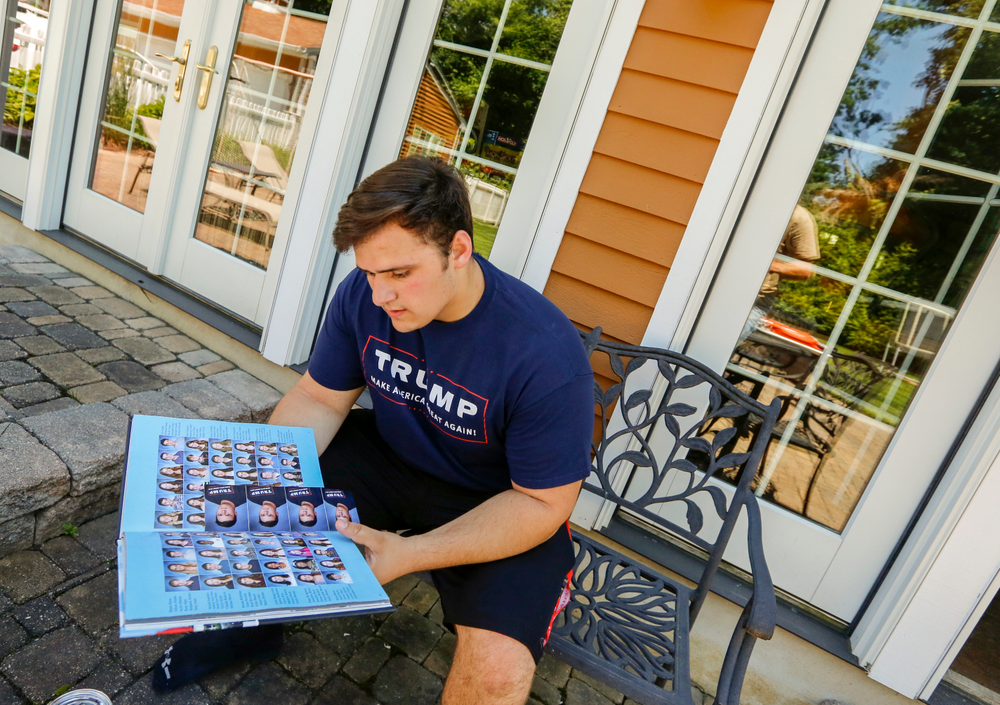 FILE - In this June 9, 2017, file photo, Grant Berardo, a student at Wall High School, flips through his 2017 school yearbook in Wall, N.J. The yearbook includes a photo of him wearing a digitally altered T-shirt that originally included the words FILE - In this June 9, 2017, file photo, Grant Berardo, a student at Wall High School, flips through his 2017 school yearbook in Wall, N.J. The yearbook includes a photo of him wearing a digitally altered T-shirt that originally included the words