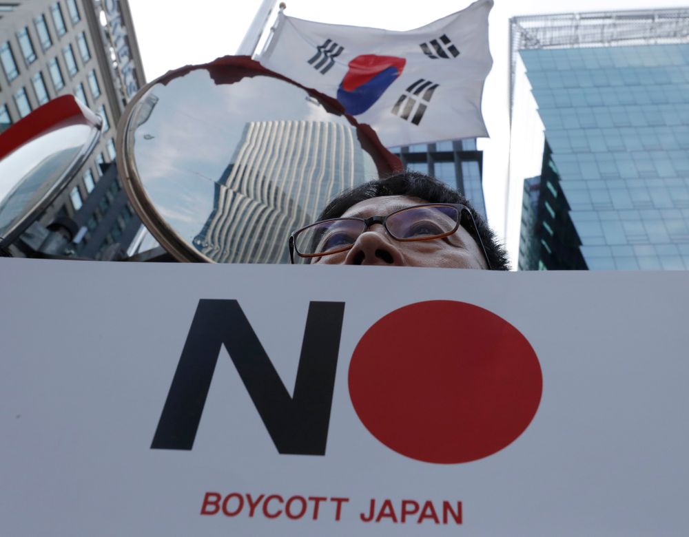 A member of the Confederation of Korean Government Employees' Unions holds a banner near the Japanese embassy in Seoul, South Korea, Tuesday, Aug. 6, 2019. South Korea's president on Monday described the country's escalating trade war with Japan as a wake-up call to revamp its economy and issued a nationalistic call for economic cooperation with North Korea, which he said would allow the Koreas to erase Japan's economic superiority in A member of the Confederation of Korean Government Employees' Unions holds a banner near the Japanese embassy in Seoul, South Korea, Tuesday, Aug. 6, 2019. South Korea's president on Monday described the country's escalating trade war with Japan as a wake-up call to revamp its economy and issued a nationalistic call for economic cooperation with North Korea, which he said would allow the Koreas to erase Japan's economic superiority in