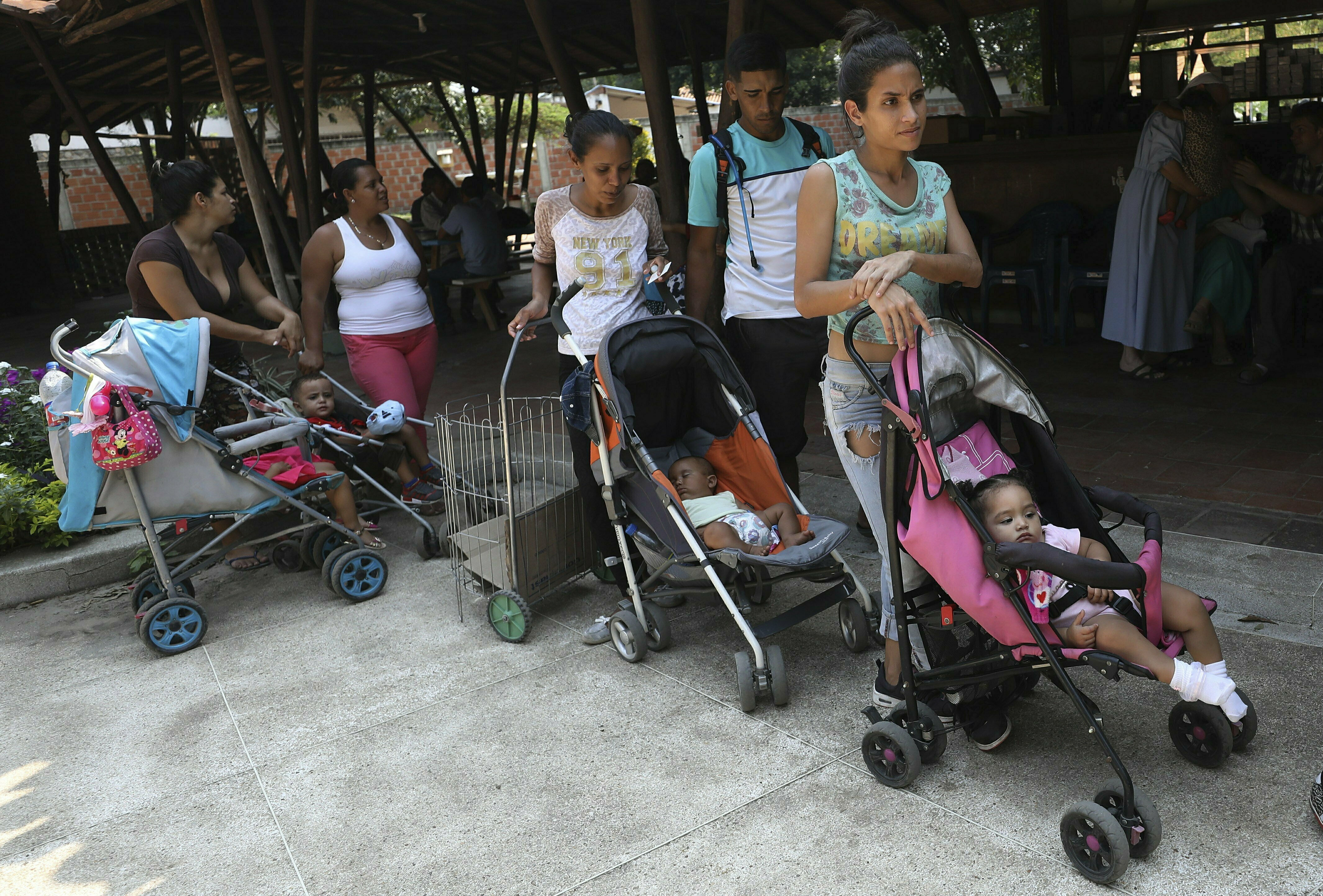 In this Feb. 4, 2019 photo, Venezuelan migrants line up with their children for a free lunch served at the In this Feb. 4, 2019 photo, Venezuelan migrants line up with their children for a free lunch served at the