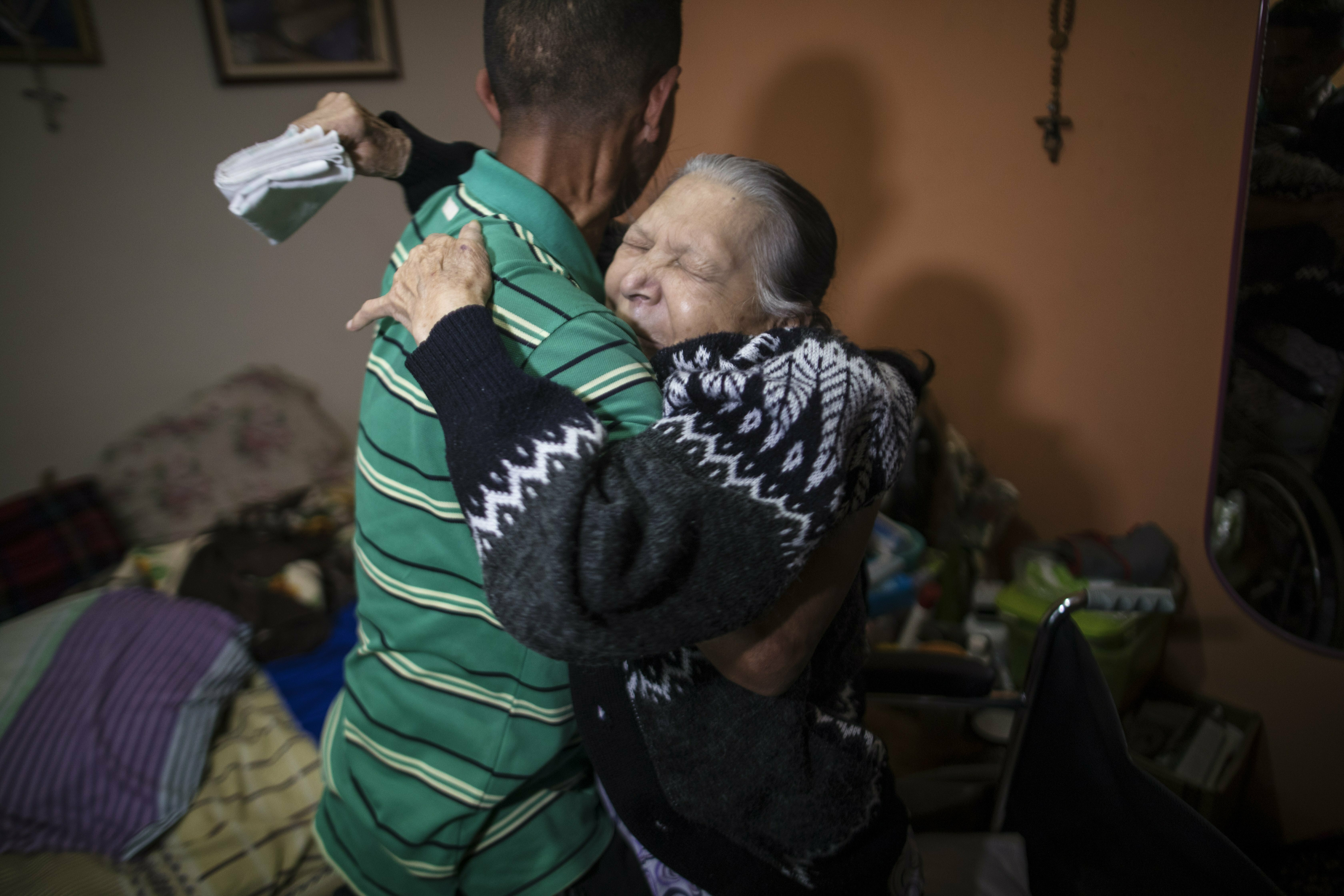 In this Feb. 4, 2019 photo, diabetes patient Aminta Villamizar, 83, is lifted into her bed by her grandson Antonio, in Caracas, Venezuela. Villamizar, a retired cleaning woman, has lost her right leg and two toes on her left one because she can’t find enough insulin to stave off diabetes. (AP Photo/Rodrigo Abd) In this Feb. 4, 2019 photo, diabetes patient Aminta Villamizar, 83, is lifted into her bed by her grandson Antonio, in Caracas, Venezuela. Villamizar, a retired cleaning woman, has lost her right leg and two toes on her left one because she can’t find enough insulin to stave off diabetes. (AP Photo/Rodrigo Abd)