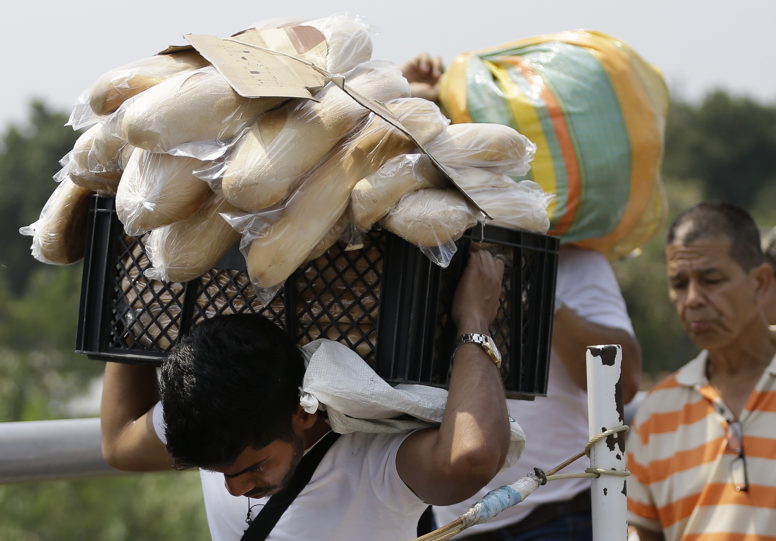 In this Feb. 4, 2019 photo, a Venezuelan man carries a crate filled with bread back to his country, in La Parada, on the outskirts of Cucuta, Colombia, on the border with Venezuela. Despite Nicolas Maduro’s longstanding rejection of outside assistance, opponents of Maduro are hastily putting together plans with U.S. officials to open a “humanitarian corridor” in Cucuta to deliver emergency food and medical supplies. (AP Photo/Fernando Vergara) In this Feb. 4, 2019 photo, a Venezuelan man carries a crate filled with bread back to his country, in La Parada, on the outskirts of Cucuta, Colombia, on the border with Venezuela. Despite Nicolas Maduro’s longstanding rejection of outside assistance, opponents of Maduro are hastily putting together plans with U.S. officials to open a “humanitarian corridor” in Cucuta to deliver emergency food and medical supplies. (AP Photo/Fernando Vergara)