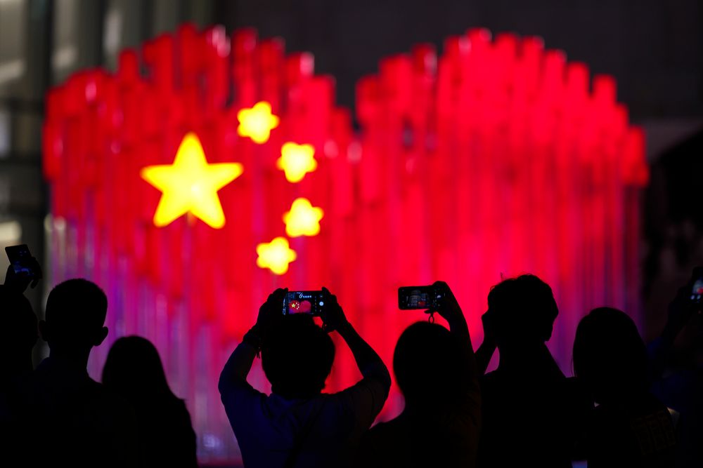 Visitors take photos with their smart phones of an installation depicting a heart shape Chinese national flag in Shanghai, China, Friday, Sept. 27, 2019. China will mark its 70th anniversary on Oct. 1, 2019. (AP Photo) Visitors take photos with their smart phones of an installation depicting a heart shape Chinese national flag in Shanghai, China, Friday, Sept. 27, 2019. China will mark its 70th anniversary on Oct. 1, 2019. (AP Photo)