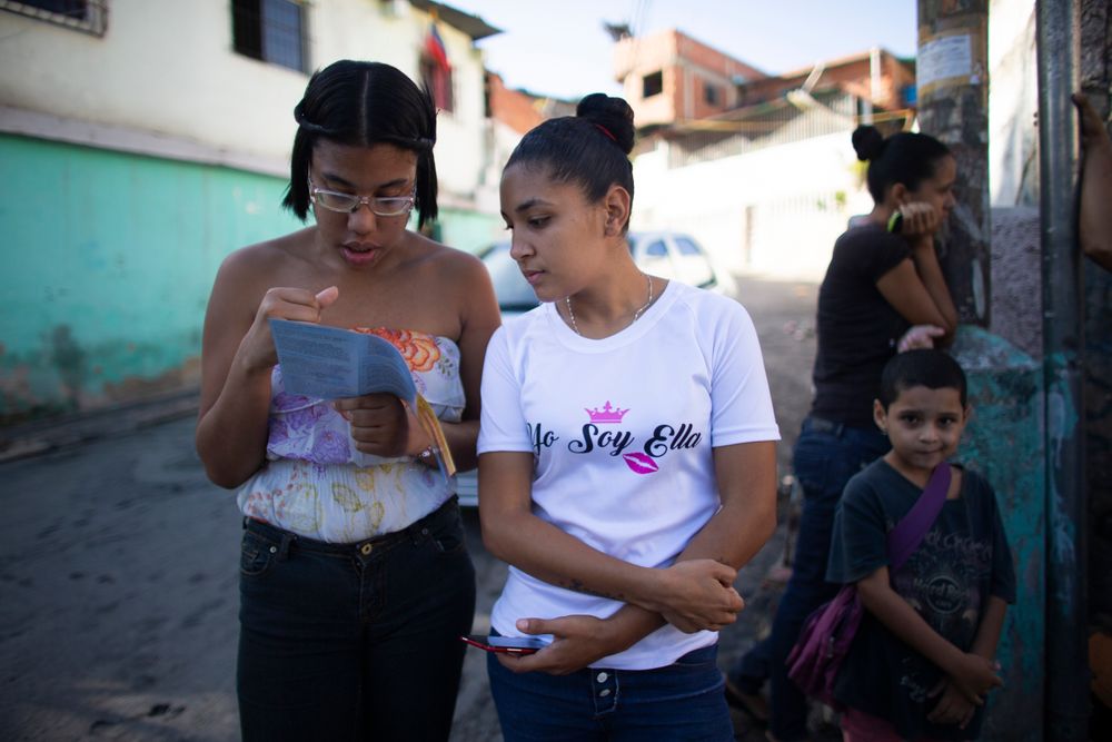 In this photo taken July 25, 2019, young women read a brochure about hormonal implants outside a clinic where a very limited number are being administered in the Caucaguita neighborhood on the outskirts of Caracas, Venezuela. “Women are getting pregnant and don’t have options,” said Luisa Kislinger, a women’s rights activist. “They’re forced into motherhood.” (AP Photo/Ariana Cubillos) In this photo taken July 25, 2019, young women read a brochure about hormonal implants outside a clinic where a very limited number are being administered in the Caucaguita neighborhood on the outskirts of Caracas, Venezuela. “Women are getting pregnant and don’t have options,” said Luisa Kislinger, a women’s rights activist. “They’re forced into motherhood.” (AP Photo/Ariana Cubillos)