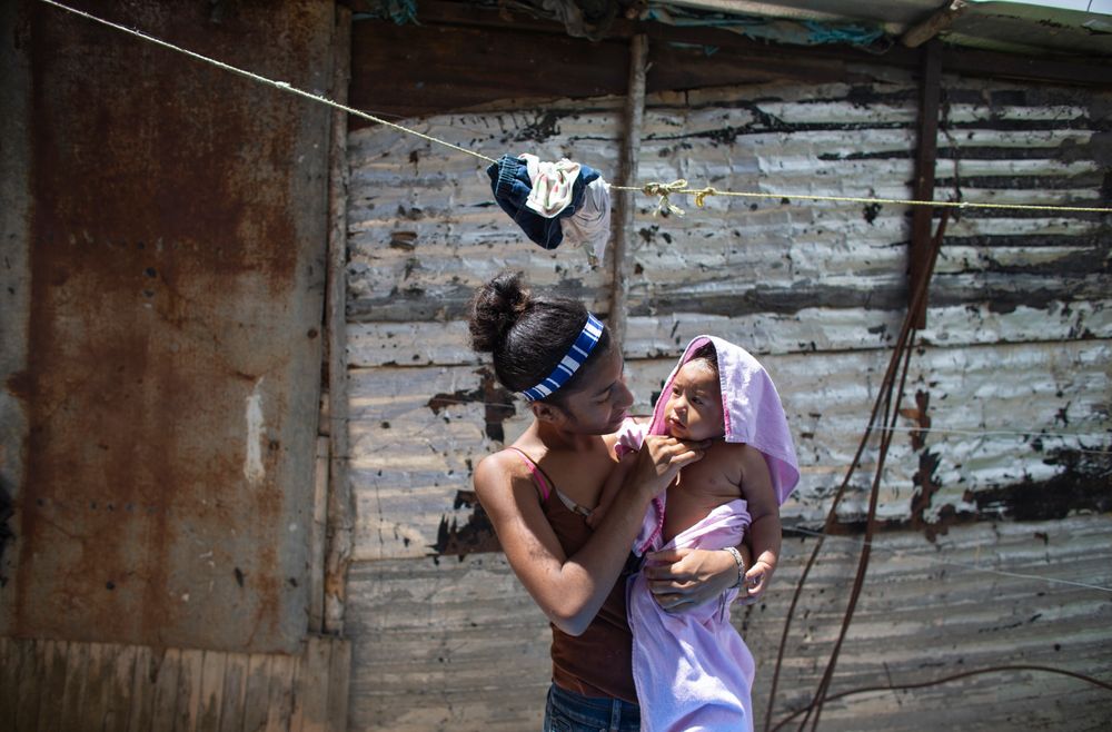 In this photo taken July 25, 2019, 15-year-old Karelys Herrera holds her baby after giving him a bath behind her home in the Caucaguita neighborhood on the outskirts of Caracas, Venezuela. Herrera said she contemplated suicide after learning she was pregnant at 14 years old. (AP Photo/Ariana Cubillos) In this photo taken July 25, 2019, 15-year-old Karelys Herrera holds her baby after giving him a bath behind her home in the Caucaguita neighborhood on the outskirts of Caracas, Venezuela. Herrera said she contemplated suicide after learning she was pregnant at 14 years old. (AP Photo/Ariana Cubillos)